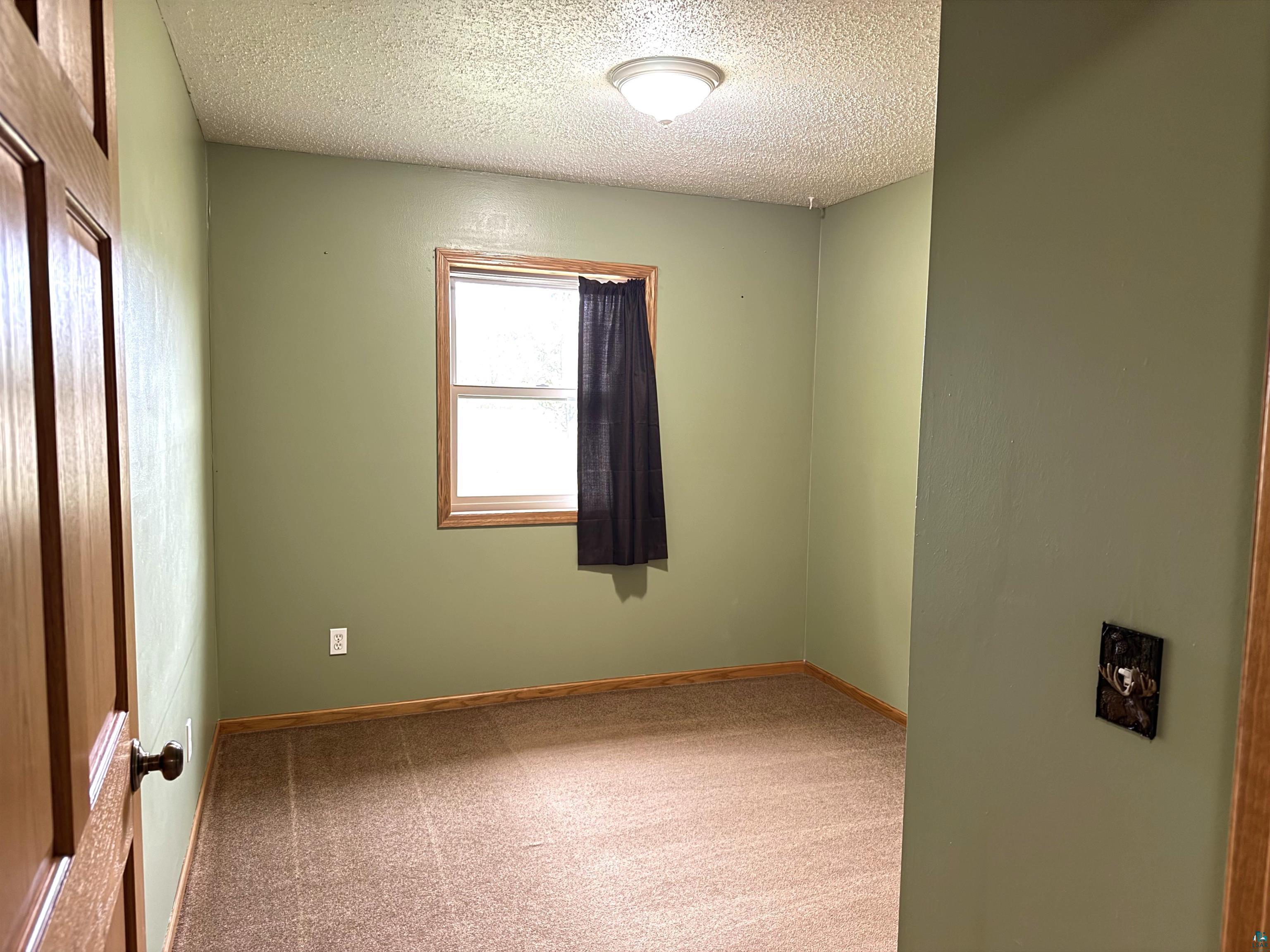 5080 Tower Road Moose Lake, MN 55767 - Photo 24 of 49 Recessed window with wood trim, wall-mounted light fixture, and textured ceiling