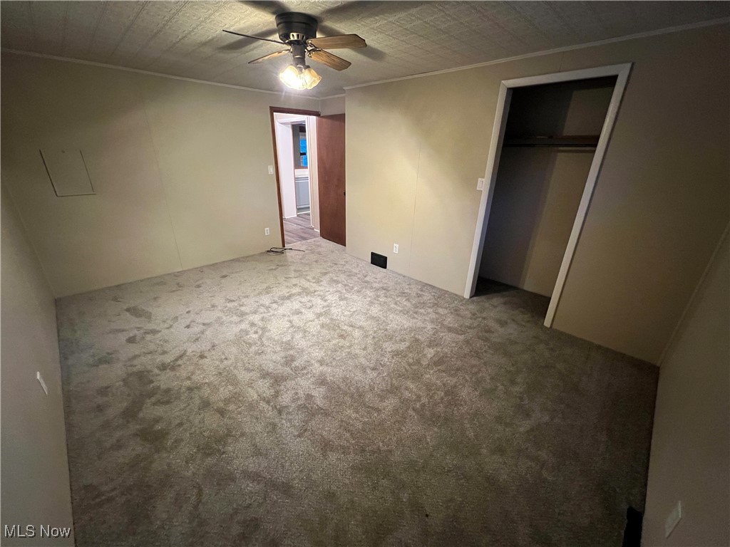 280 Holly Road Northwest Dellroy, OH 44620 - Photo 18 of 26 Unfurnished bedroom with ornamental molding, a closet, ceiling fan, and carpet floors