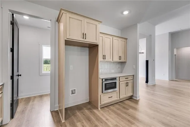 a view of a kitchen with wooden floor and electronic appliances