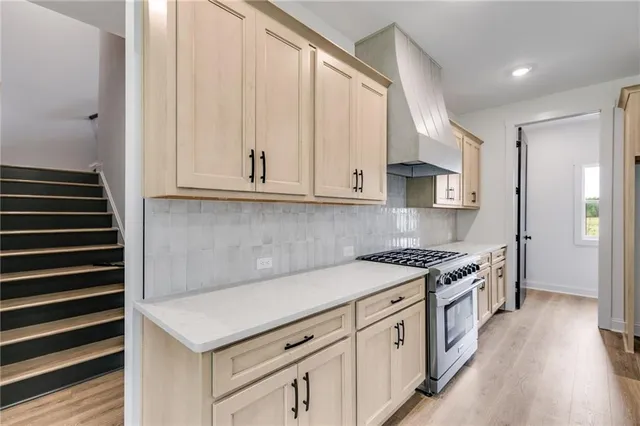 a kitchen with stainless steel appliances white cabinets and a stove top oven