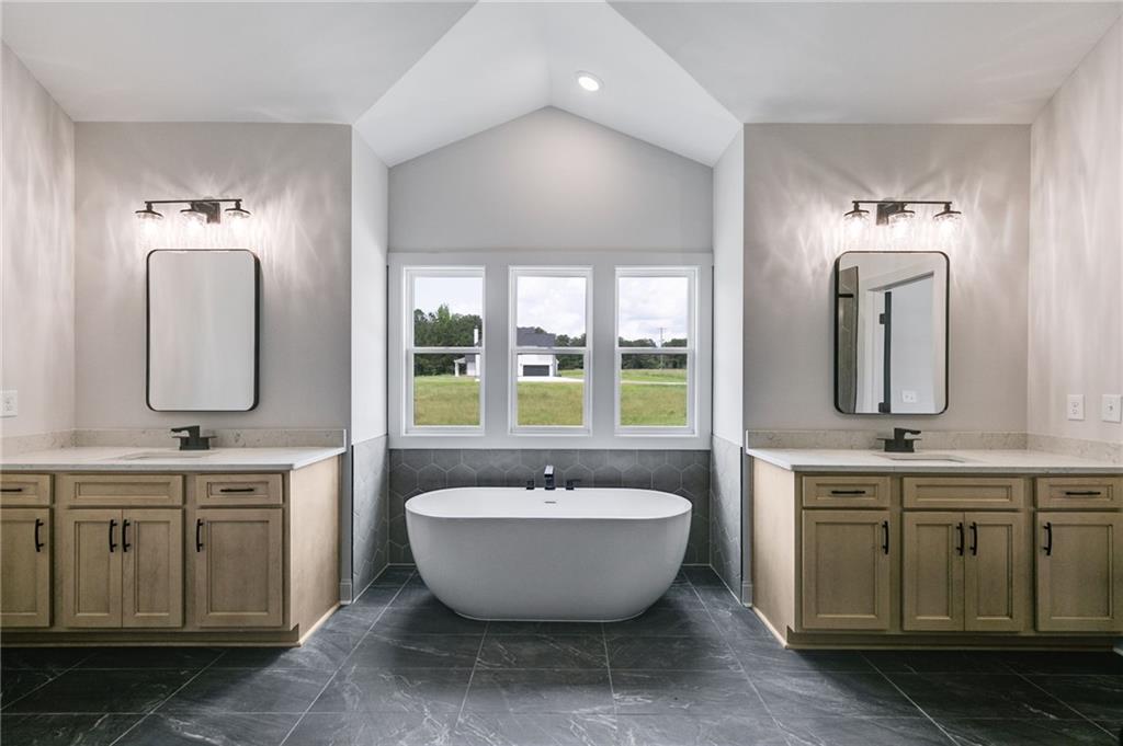 728 Lake Cir Road Buchanan, GA 30113 - Photo 25 of 50 a spacious bathroom with a double vanity sink a mirror and a bathtub
