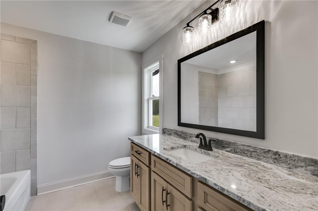728 Lake Cir Road Buchanan, GA 30113 - Photo 37 of 50 a bathroom with a granite countertop sink a toilet and a mirror
