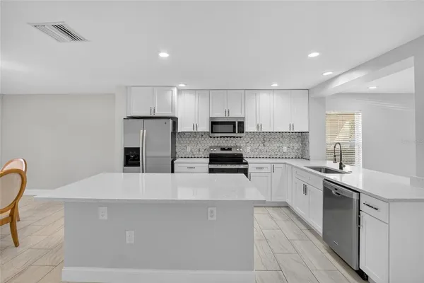 a kitchen with stainless steel appliances a refrigerator sink stove microwave and cabinets