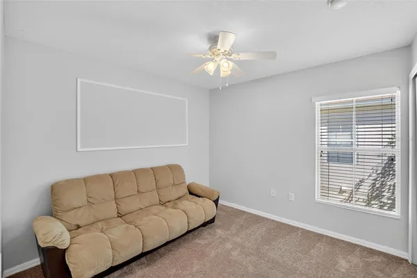 a living room with furniture and a ceiling fan