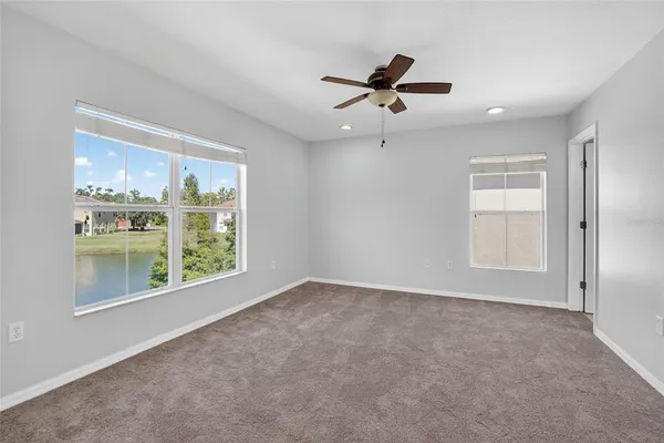 an empty room with a ceiling fan and window