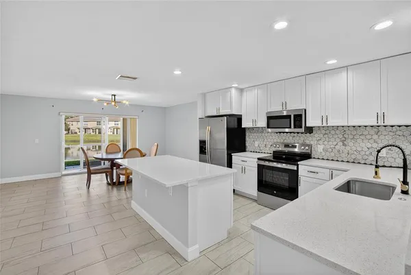 a kitchen with stainless steel appliances a sink and a refrigerator