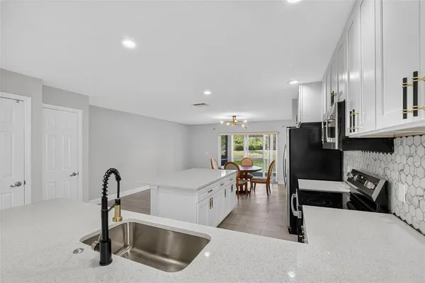 a kitchen with stainless steel appliances a refrigerator sink and white cabinets