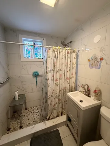 a bathroom with a sink mirror and shower