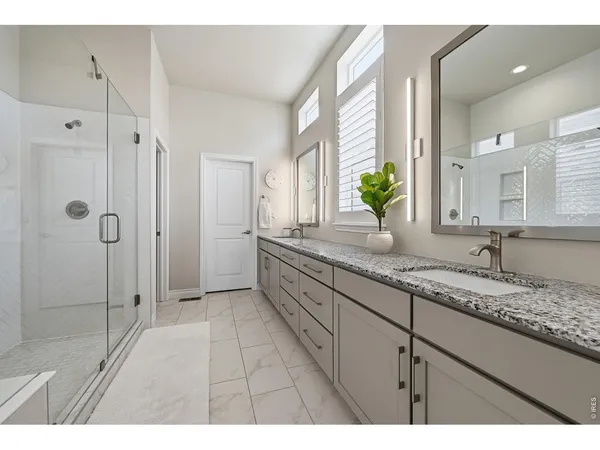 a bathroom with a granite countertop sink mirror and shower