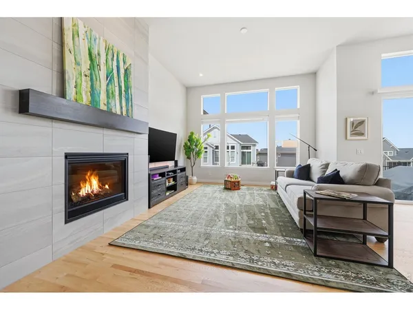 a living room with furniture a fireplace a flat screen tv and a large window