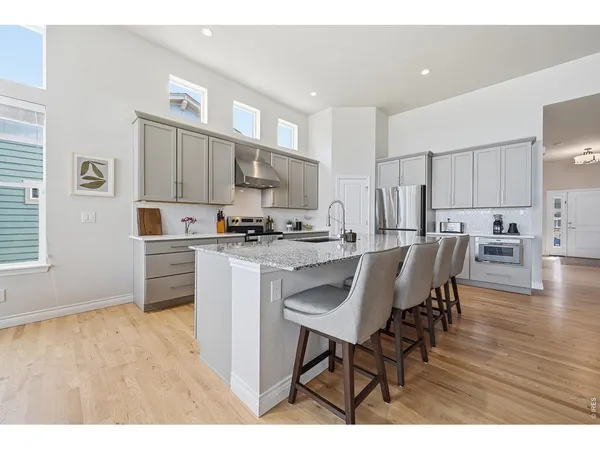 a kitchen with kitchen island granite countertop a sink cabinets and wooden floor