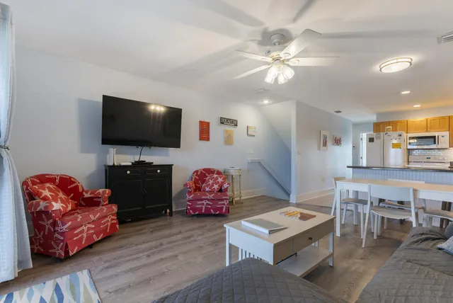 a kitchen with stainless steel appliances a dining table chairs and wooden floor