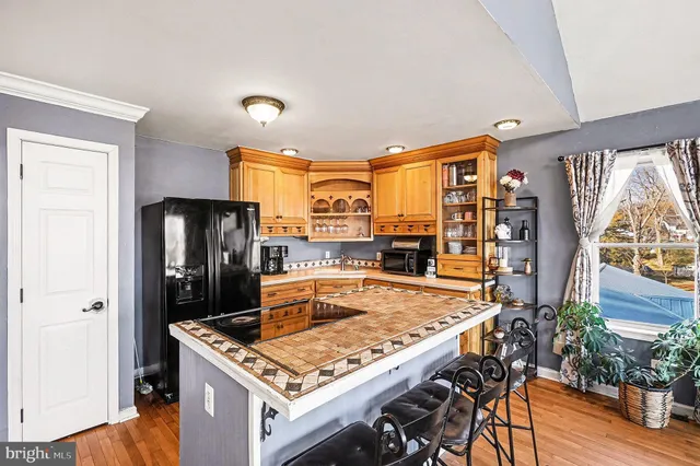 a kitchen with stainless steel appliances granite countertop a refrigerator a stove and a wooden floors