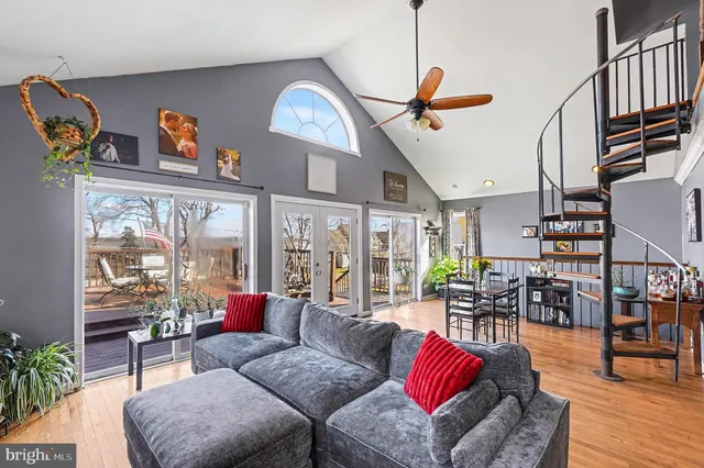 a living room with furniture kitchen view and a large window