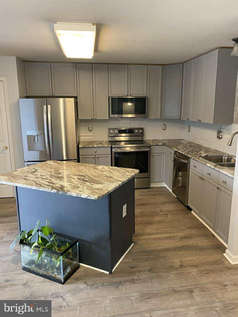94 Eldon Drive Charles Town, WV 25414 - Photo 7 of 24 a kitchen with kitchen island granite countertop wooden cabinets stainless steel appliances and sink