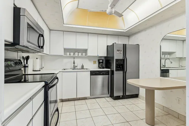 a kitchen with a sink a refrigerator and a stove top oven