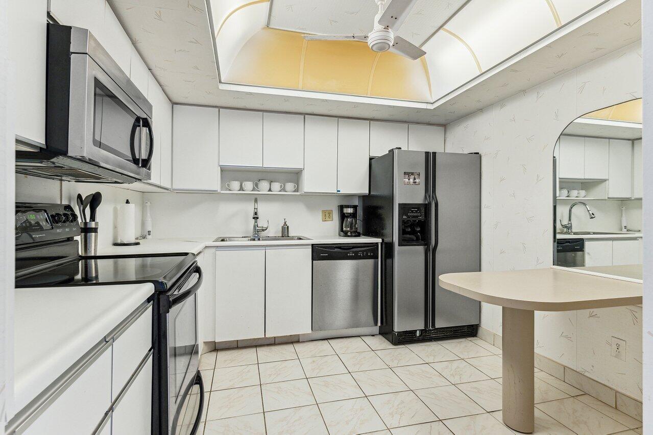 3610 South Ocean Boulevard, Unit 502 South Palm Beach, FL 33480 - Photo 16 of 51 a kitchen with a sink a refrigerator and a stove top oven