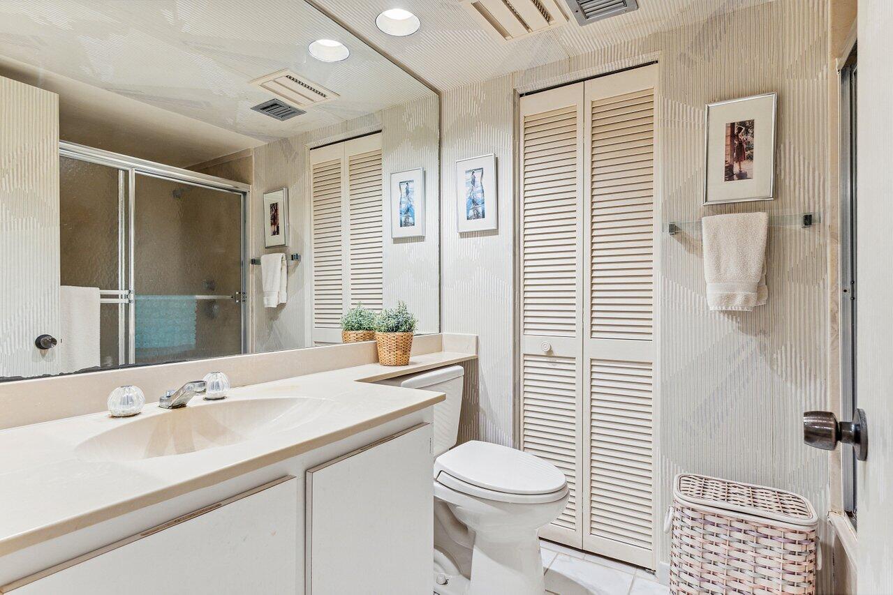 3610 South Ocean Boulevard, Unit 502 South Palm Beach, FL 33480 - Photo 24 of 51 a bathroom with a sink a toilet a mirror and shower