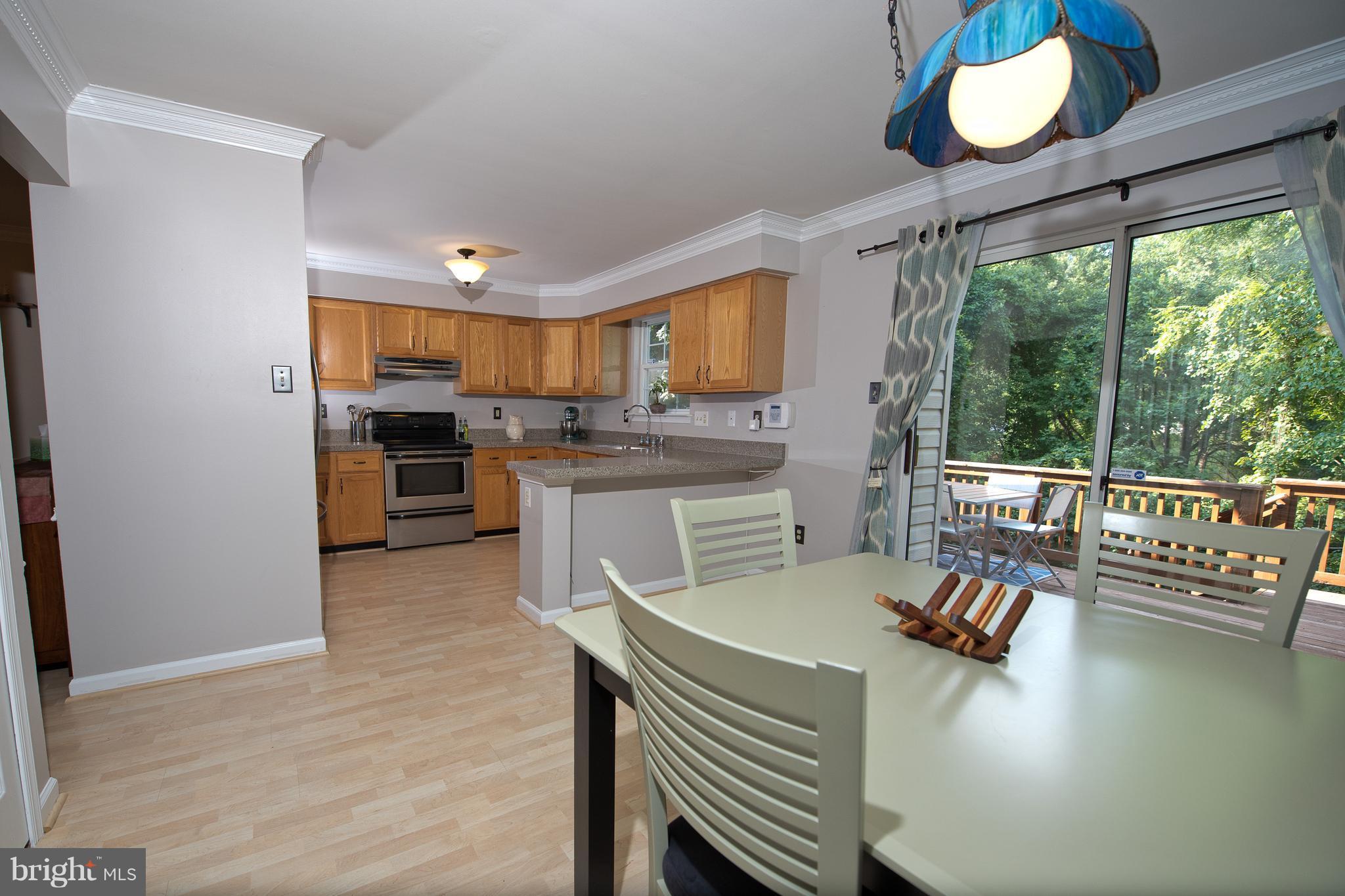 6163 Good Hunters Ride Columbia, MD 21045 - Photo 9 of 30 a kitchen with a table chairs stove and refrigerator