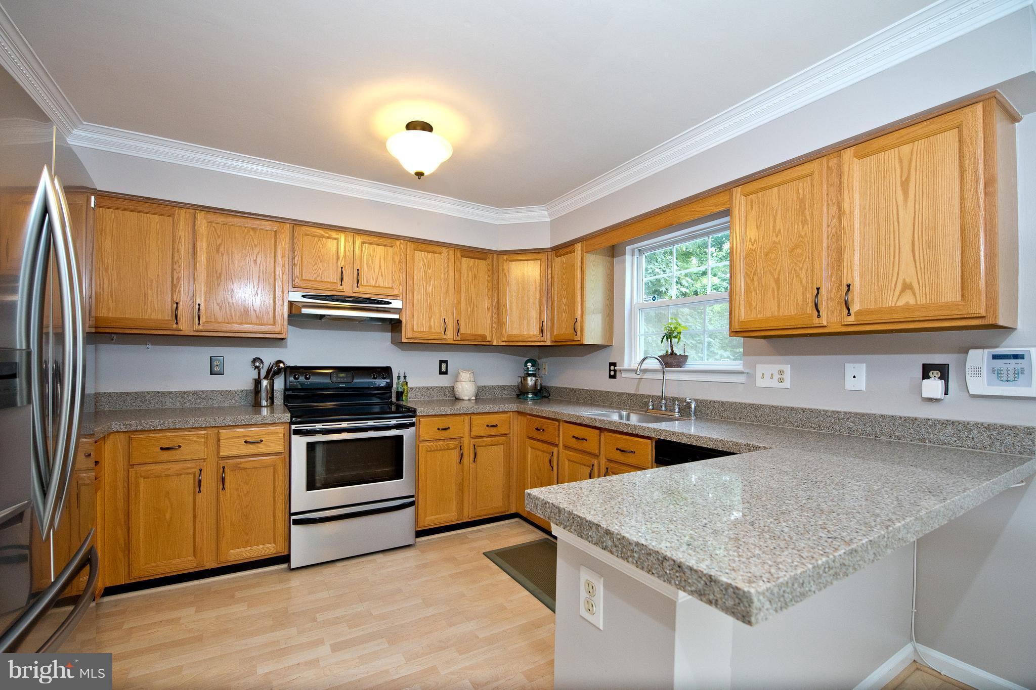 6163 Good Hunters Ride Columbia, MD 21045 - Photo 10 of 30 a kitchen with stainless steel appliances granite countertop wooden cabinets a sink and a stove