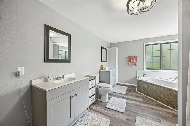 a spacious bathroom with a double vanity sink a mirror and a bathtub