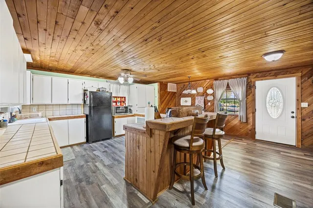 a kitchen with stainless steel appliances granite countertop a table chairs and a refrigerator