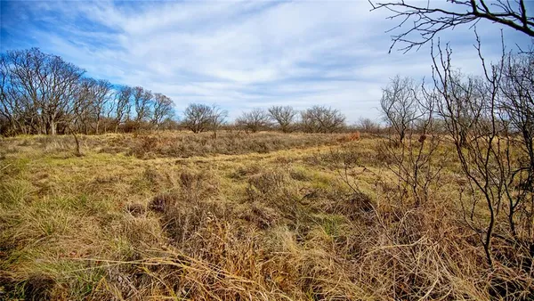 a view of a lake with beach and house in the background
