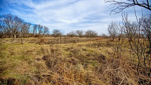 a view of a lake with beach and house in the background