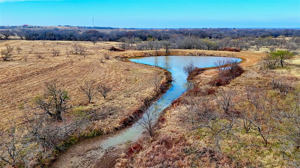 0 Carpenter Road Nocona, TX 76255 - Photo 18 of 24 a view of a lake with beach and house in the background