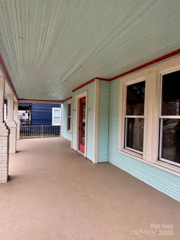 a view of an empty room with a window and fireplace
