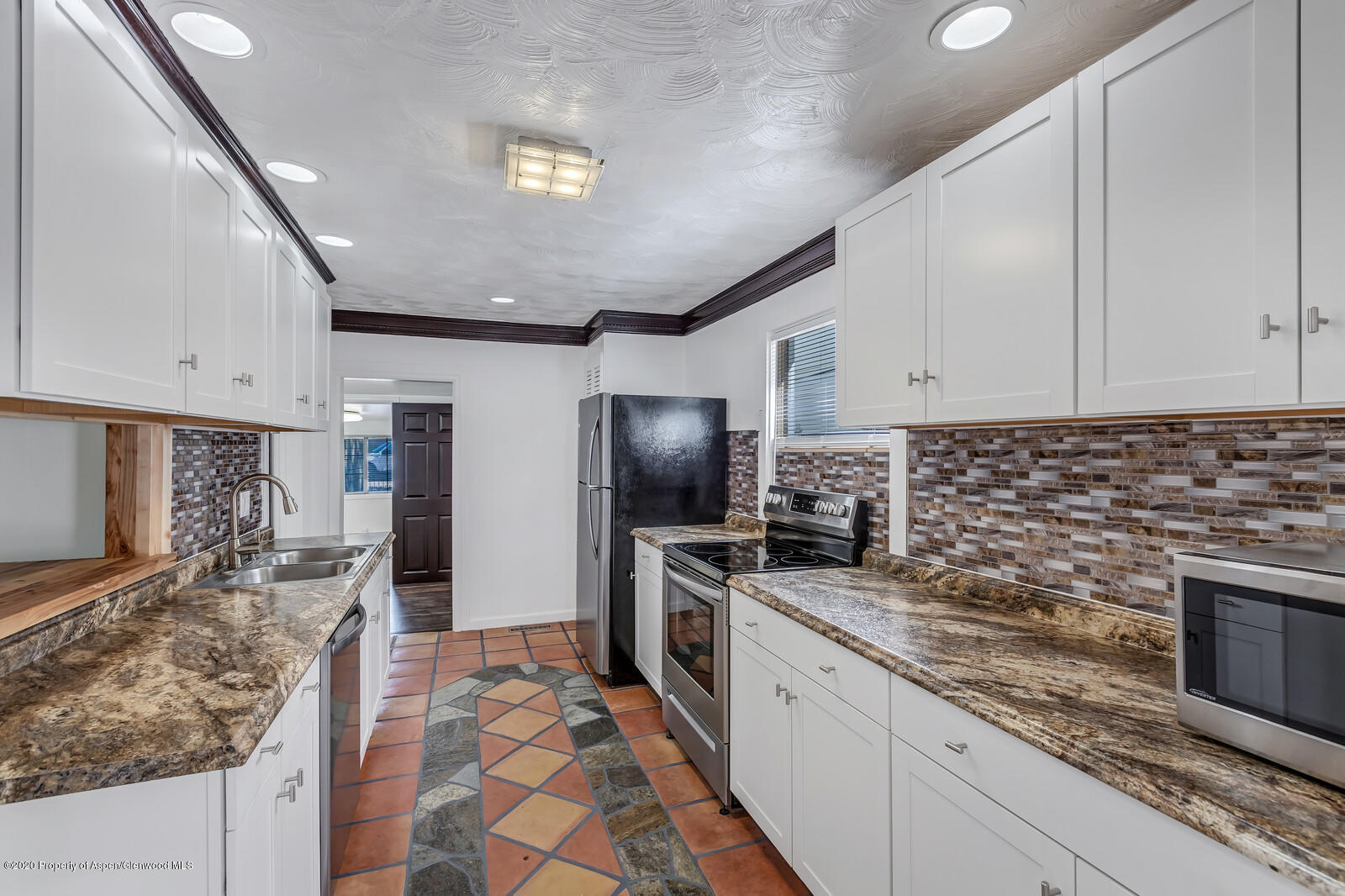 216 West 4th Street Rifle, CO 81650 - Photo 7 of 17 a kitchen with granite countertop stainless steel appliances a sink stove top oven and cabinets