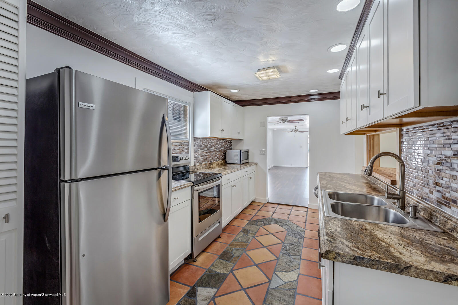 216 West 4th Street Rifle, CO 81650 - Photo 8 of 17 a kitchen with granite countertop a refrigerator and a sink