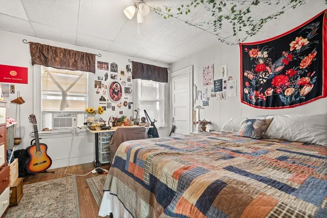 a bedroom with 2 bed and a painting on the wall