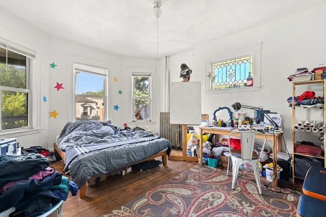 a bedroom that has a bed a desk and a baby crib