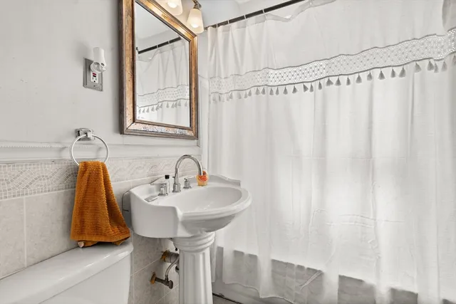 a bathroom with a sink a mirror and a shower curtain