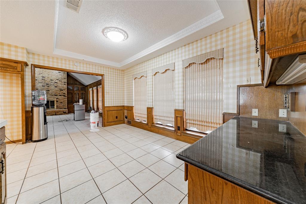 4320 Hickox Road Rowlett, TX 75089 - Photo 32 of 37 Tile flooring, dark countertops, wood cabinetry, wainscoting, and recessed ceiling with decorative molding