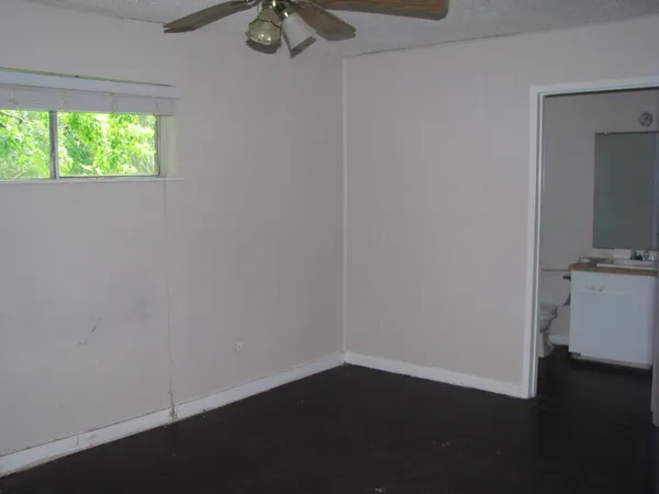 a view of a small space with wooden floor and a window