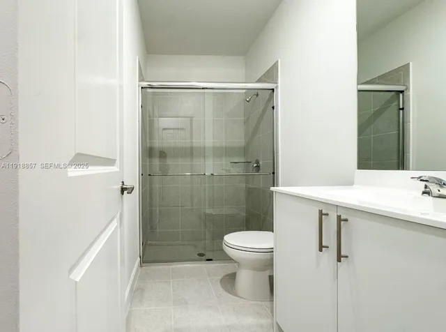 a bathroom with a shower sink vanity and toilet