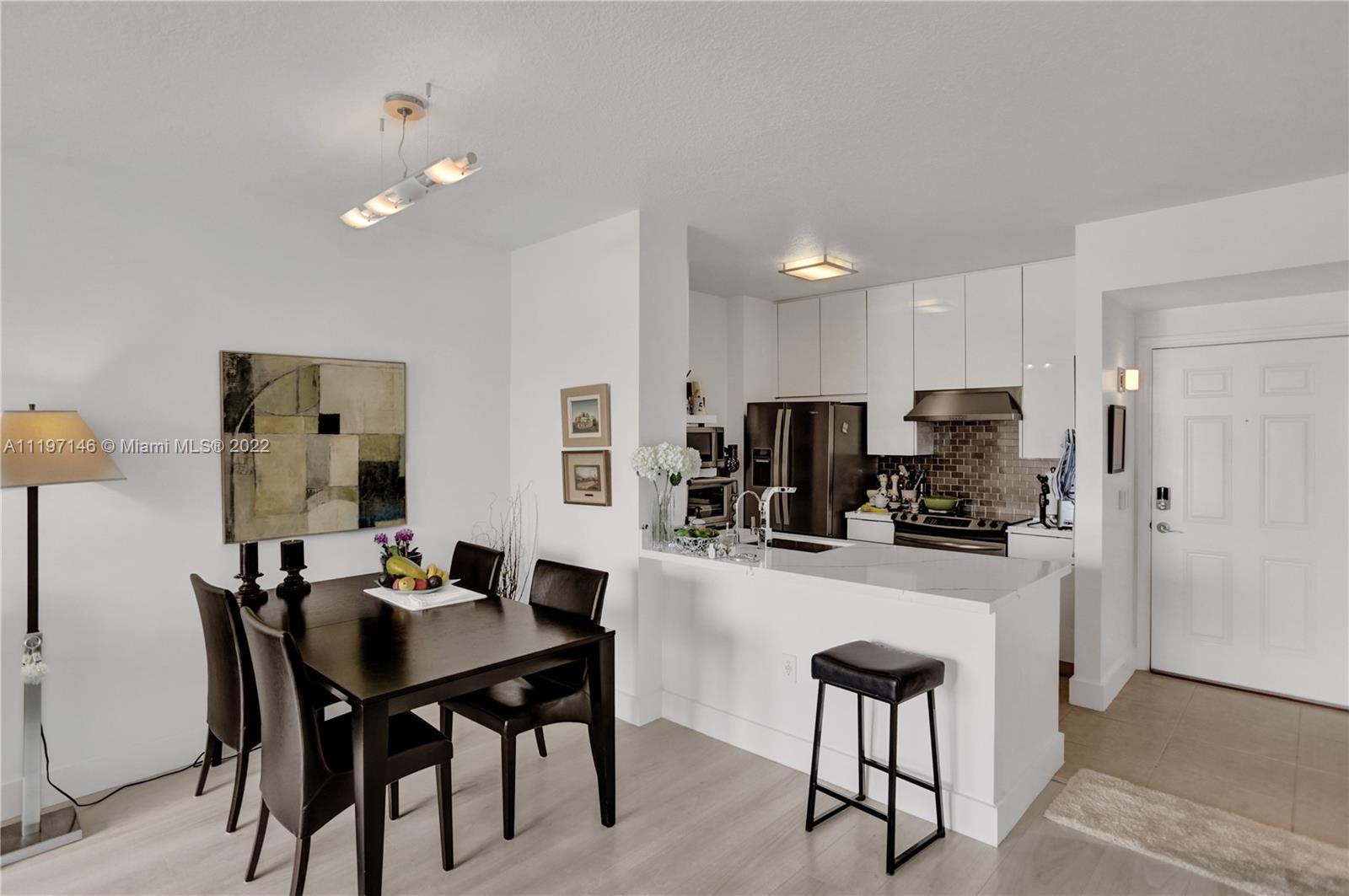 Imperial Point Fort Lauderdale, FL 33308 - Photo 21 of 37 a kitchen with stainless steel appliances kitchen island granite countertop a dining table chairs and a refrigerator