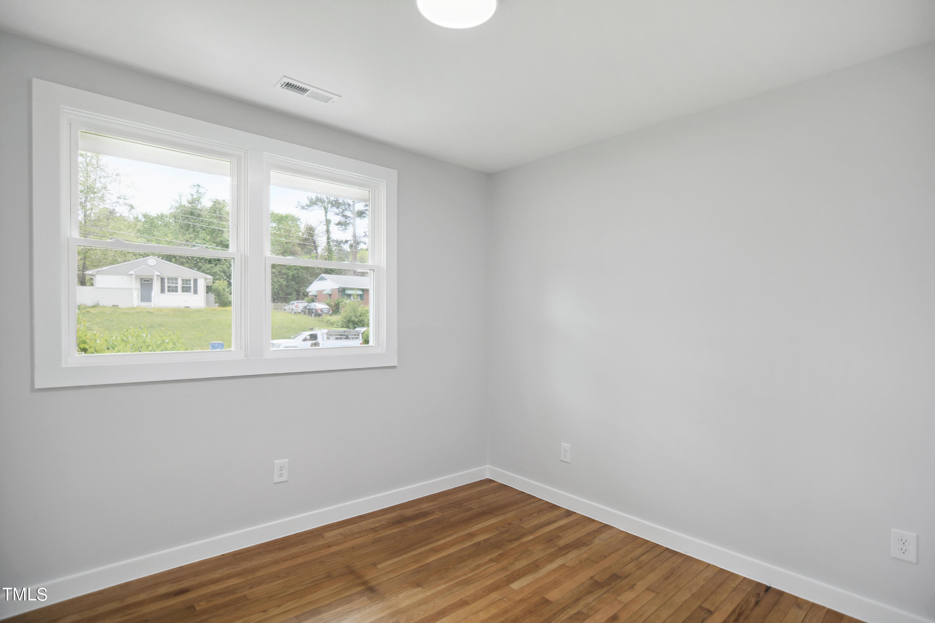 817 Newcombe Road Raleigh, NC 27610 - Photo 11 of 13 an empty room with wooden floor and windows