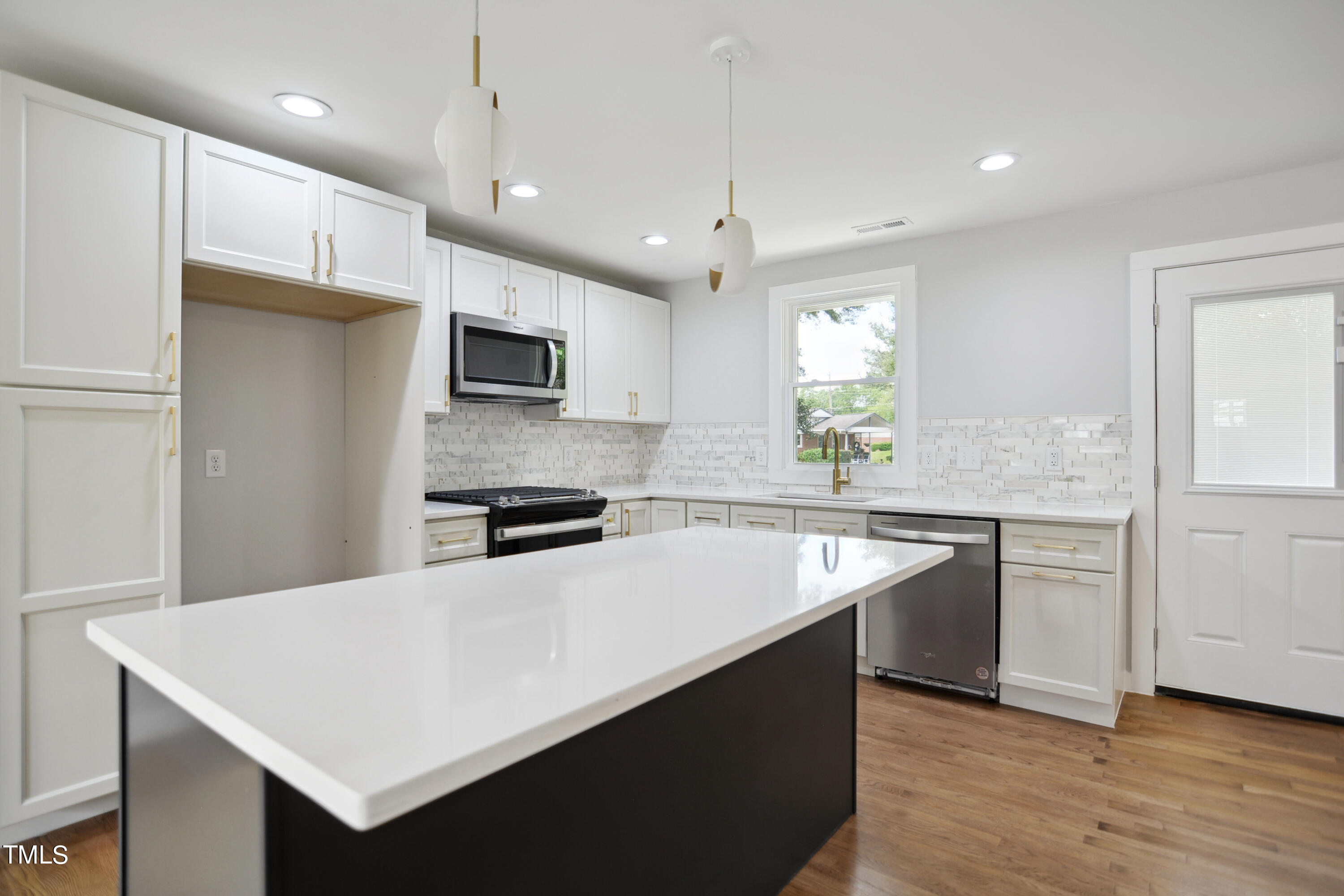 817 Newcombe Road Raleigh, NC 27610 - Photo 4 of 13 a kitchen with a sink a stove a refrigerator and a microwave