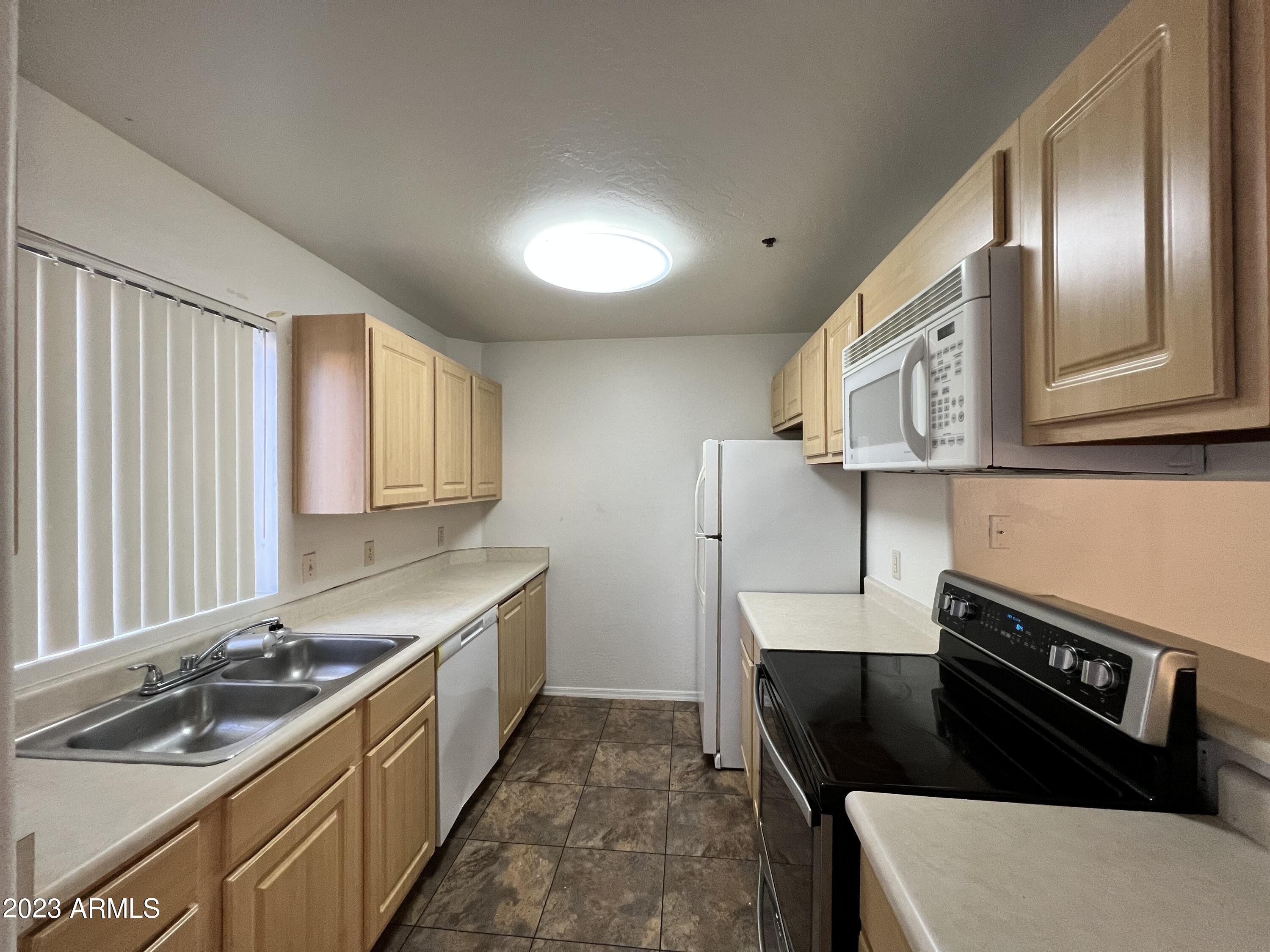 1287 North Alma School Road, Unit 224 Chandler, AZ 85224 - Photo 2 of 8 a kitchen with stainless steel appliances granite countertop a sink stove and refrigerator
