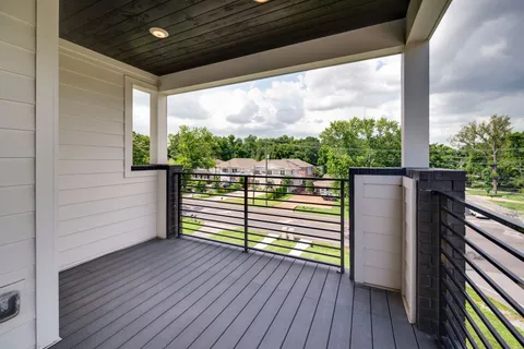 a view of an empty room with wooden floor and windows