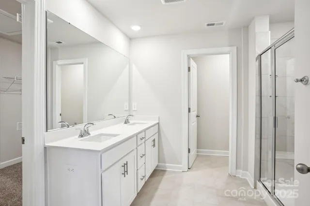 a bathroom with a double vanity sink and mirror