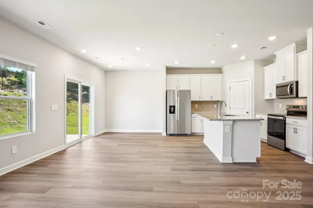 a view of a kitchen with a sink a refrigerator and window