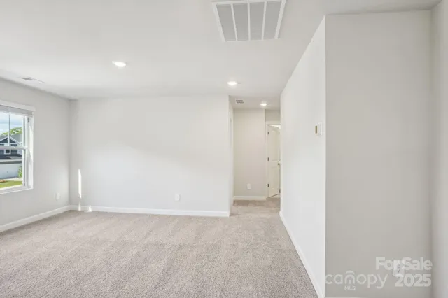 an empty room with windows and entrance to other room