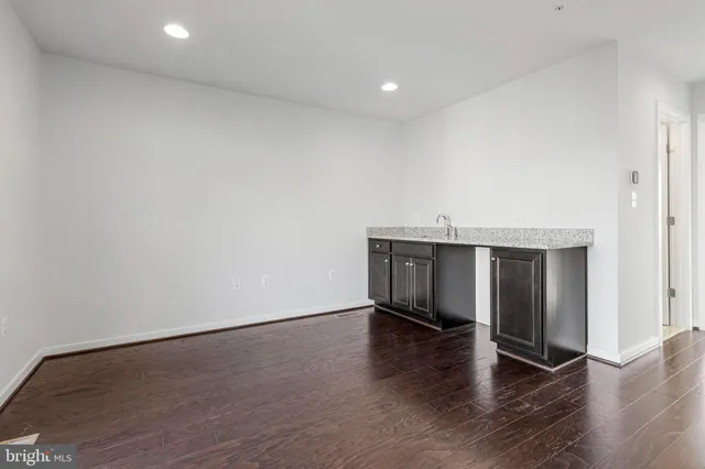 a view of an empty room with wooden floor and closet