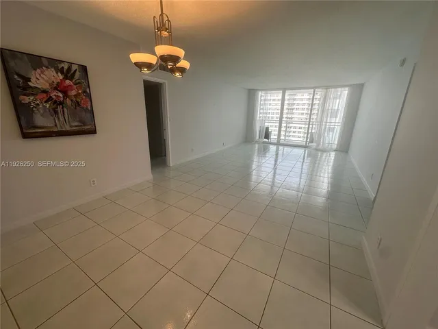 a view of a livingroom with a chandelier fan and windows