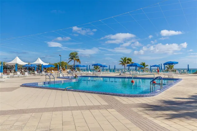 a view of swimming pool with outdoor seating and plants