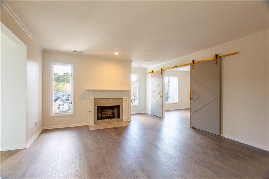 45 St Claire Lane Northeast Atlanta, GA 30324 - Photo 14 of 29 an empty room with wooden floor fireplace and windows